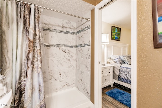 bathroom with a shower with curtain, a textured ceiling, and hardwood / wood-style flooring