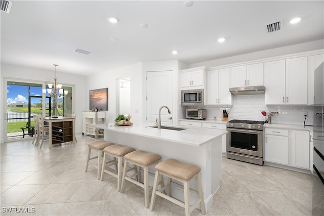 kitchen featuring white cabinetry, appliances with stainless steel finishes, sink, and a kitchen island with sink