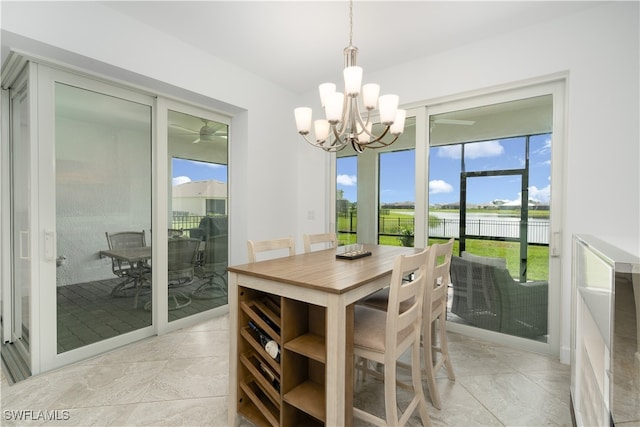 dining space featuring a water view and a notable chandelier