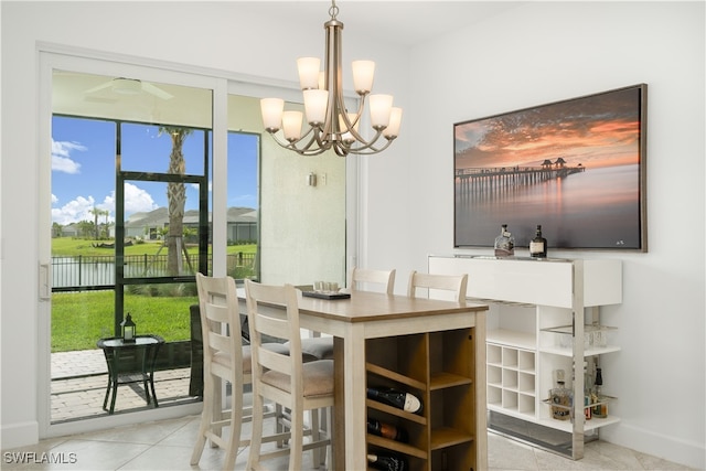 dining area with a chandelier, light tile patterned floors, and a water view