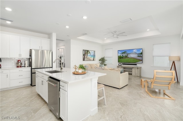 kitchen featuring white cabinetry, stainless steel appliances, a kitchen island with sink, and sink