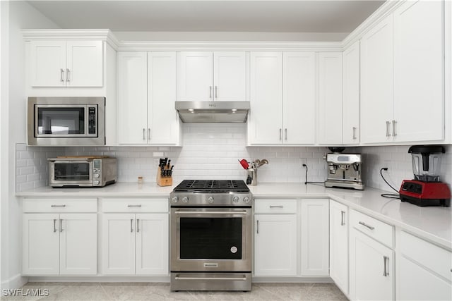 kitchen with tasteful backsplash, white cabinets, and stainless steel appliances