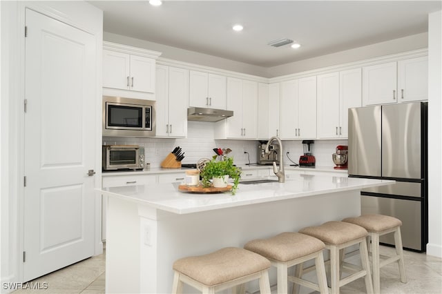 kitchen featuring sink, white cabinets, a kitchen island with sink, and stainless steel appliances