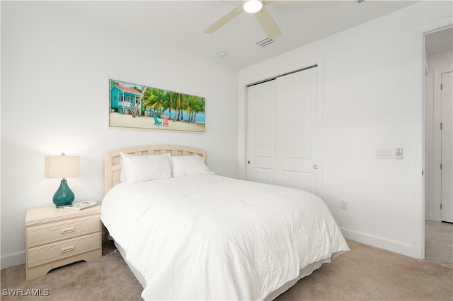 carpeted bedroom with ceiling fan and a closet