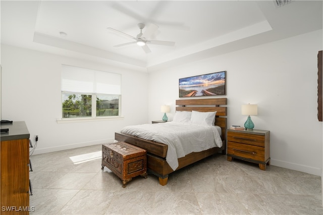 bedroom with a tray ceiling and ceiling fan