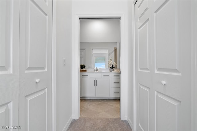 hall with light tile patterned floors and sink