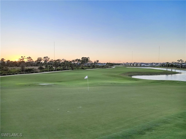 view of home's community with a water view and a lawn