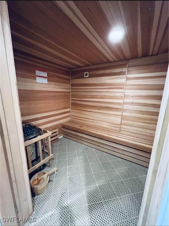 view of sauna / steam room featuring tile patterned flooring, wood walls, and wood ceiling