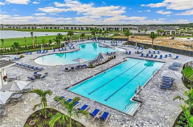 view of swimming pool with a water view and a patio area