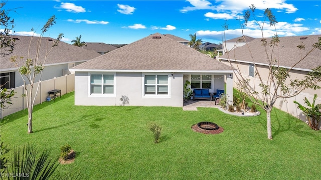 back of property featuring a lawn, a patio area, and an outdoor fire pit