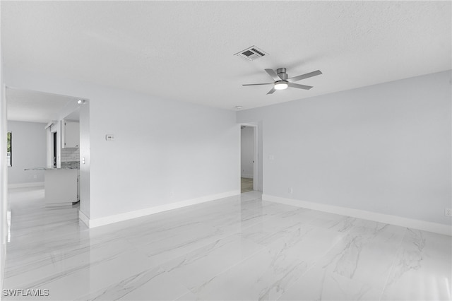 empty room featuring ceiling fan and a textured ceiling