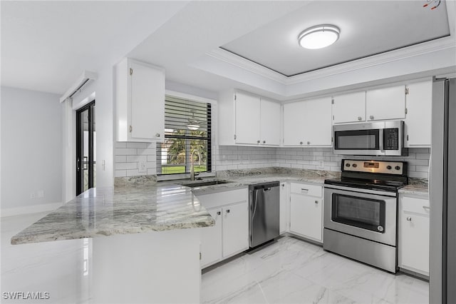 kitchen with kitchen peninsula, appliances with stainless steel finishes, sink, and white cabinets