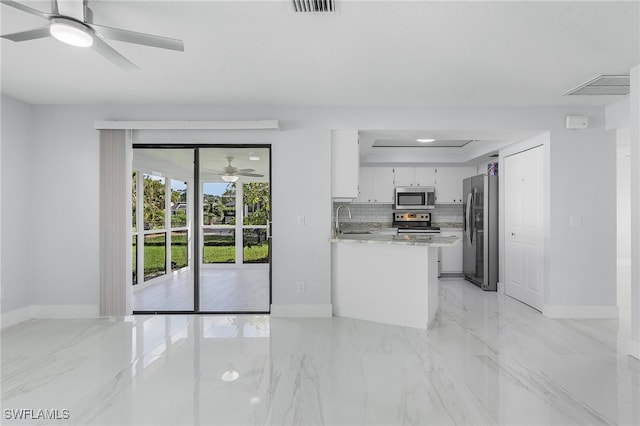 kitchen featuring light stone counters, stainless steel appliances, white cabinetry, sink, and kitchen peninsula