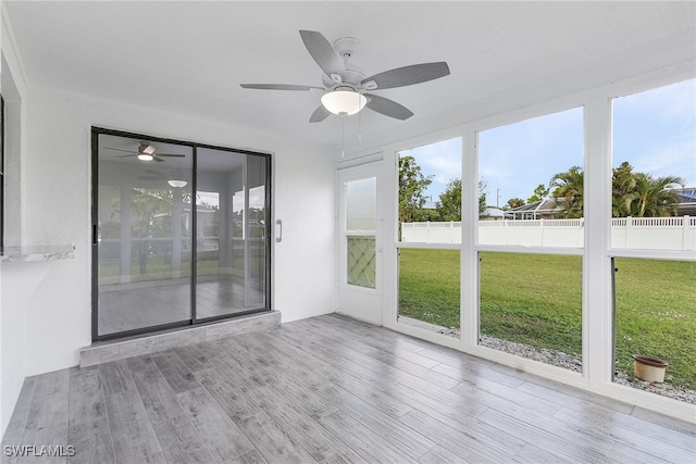 unfurnished sunroom with ceiling fan