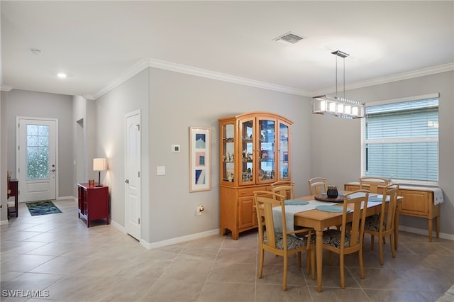 tiled dining area featuring crown molding