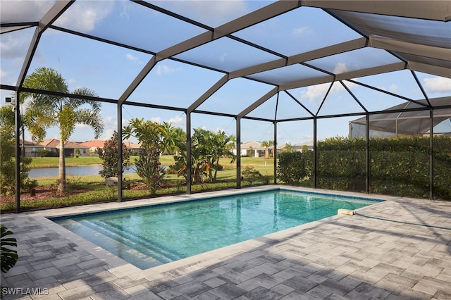 view of pool with glass enclosure, a water view, and a patio