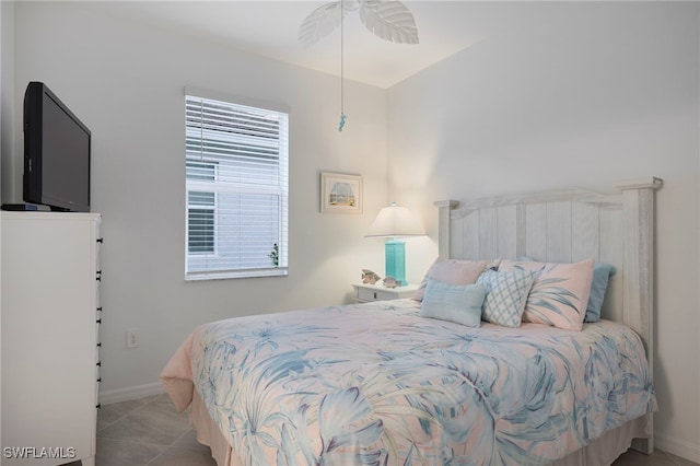 bedroom with multiple windows, light tile patterned floors, and ceiling fan