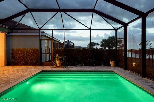 view of pool with a patio area and a lanai