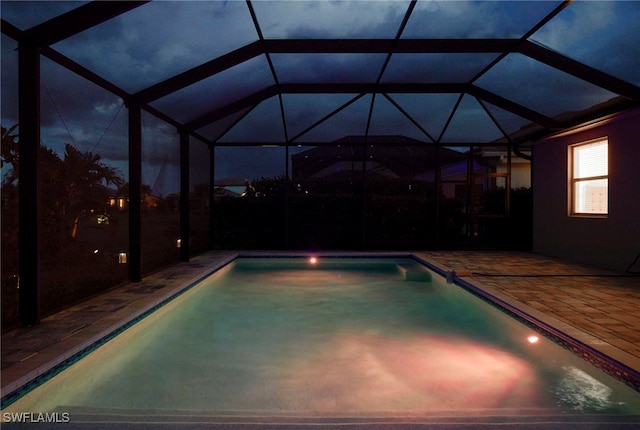 view of pool with glass enclosure and a patio area