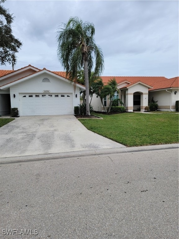 ranch-style home with a garage and a front lawn