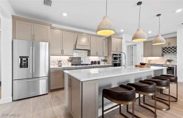 kitchen with backsplash, hanging light fixtures, premium range hood, and stainless steel appliances