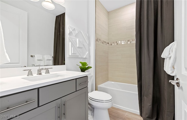 full bathroom featuring hardwood / wood-style floors, vanity, toilet, and shower / tub combo with curtain