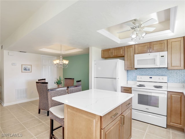 kitchen featuring pendant lighting, a center island, white appliances, a raised ceiling, and tasteful backsplash