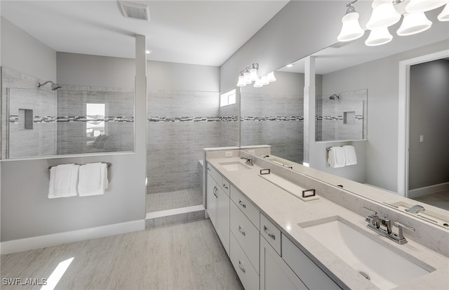 bathroom with tiled shower, wood-type flooring, and vanity