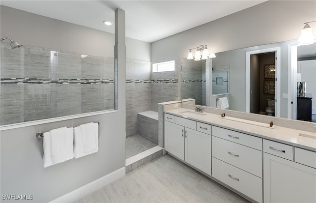 bathroom featuring hardwood / wood-style flooring, vanity, toilet, and tiled shower