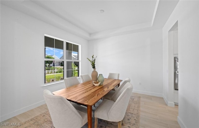 42202 Lake Timber Dr, Punta Gorda, FL 33982 - dining room featuring a tray ceiling and light wood-type flooring