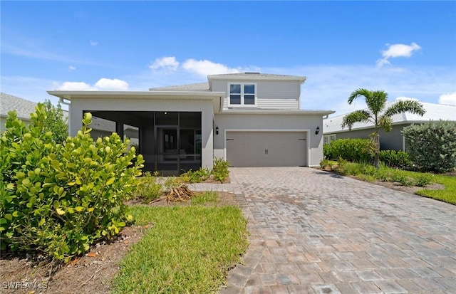 42202 Lake Timber Dr, Punta Gorda, FL 33982 - view of front facade with a sunroom, decorative driveway, stucco siding, and a garage