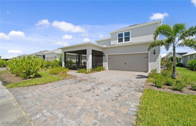 42202 Lake Timber Dr, Punta Gorda, FL 33982 - view of front of property featuring a garage, decorative driveway, a sunroom, and stucco siding