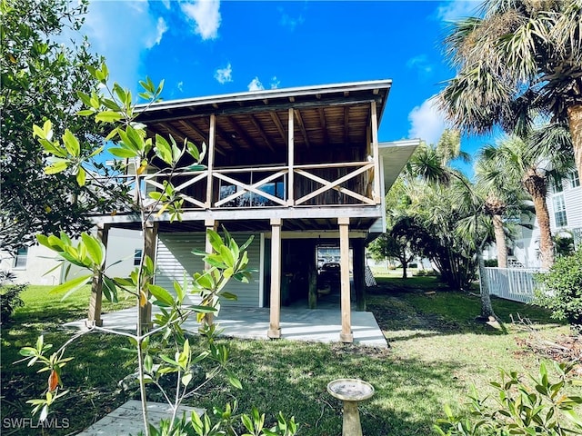 rear view of property with a lawn and a patio