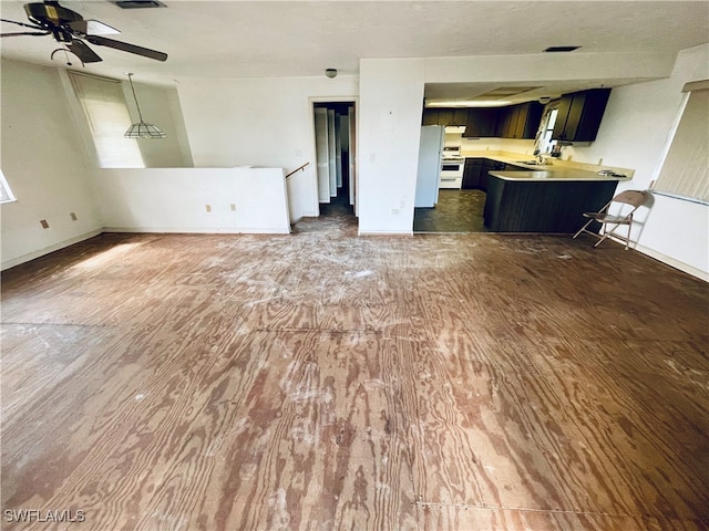 unfurnished living room featuring dark hardwood / wood-style floors, ceiling fan, and sink