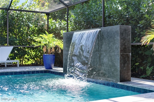 view of swimming pool featuring a lanai and pool water feature