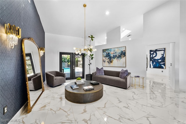 living room featuring french doors, a towering ceiling, a chandelier, and tile walls