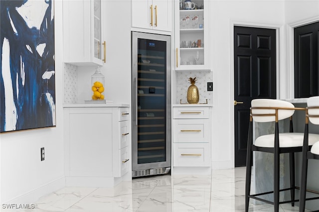 kitchen featuring backsplash, wine cooler, white cabinets, and a breakfast bar area