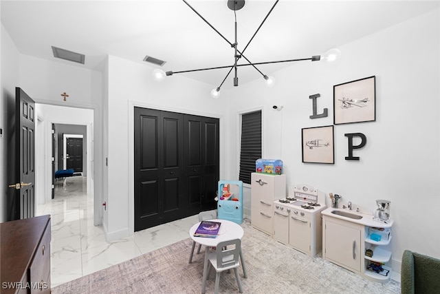 game room featuring an inviting chandelier