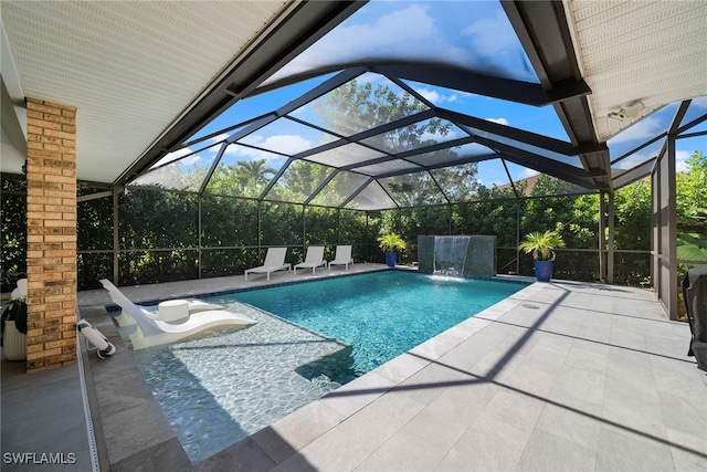 view of swimming pool with glass enclosure, pool water feature, and a patio