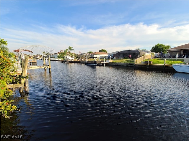 view of dock with a yard and a water view