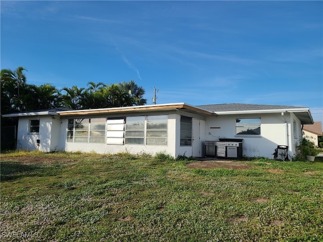 rear view of property featuring a lawn