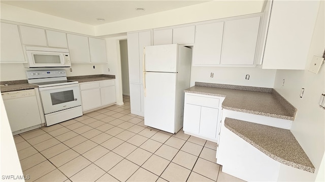 kitchen featuring white appliances, light tile patterned floors, and white cabinets