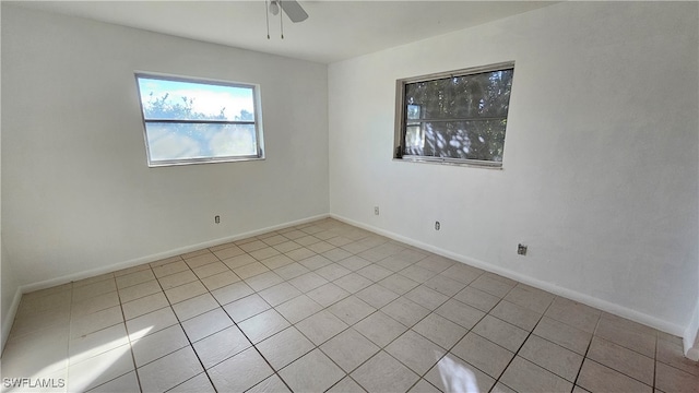 tiled spare room with ceiling fan