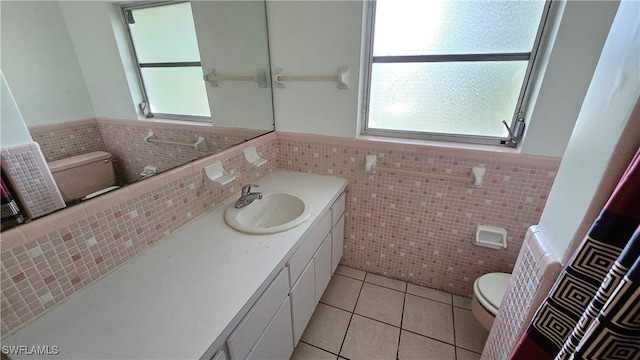 bathroom with vanity, tile patterned flooring, toilet, and tile walls