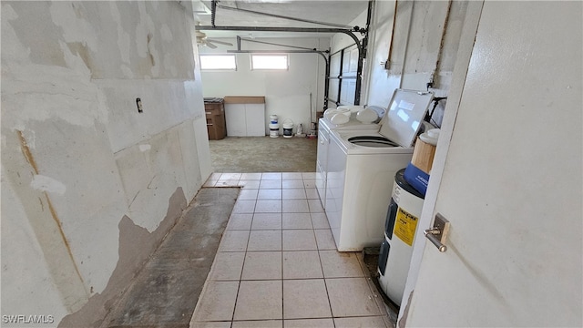 washroom with electric water heater, separate washer and dryer, and light tile patterned floors