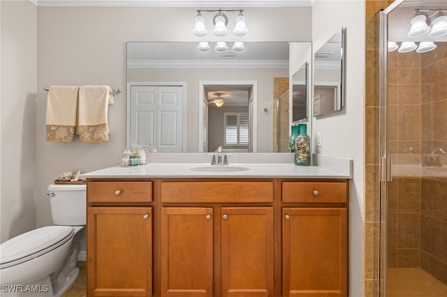 bathroom featuring toilet, a shower with shower door, vanity, and crown molding