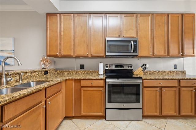 kitchen with stainless steel appliances, light tile patterned flooring, sink, ornamental molding, and light stone countertops