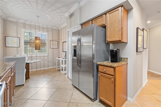 kitchen with light stone countertops, light tile patterned floors, crown molding, and stainless steel fridge