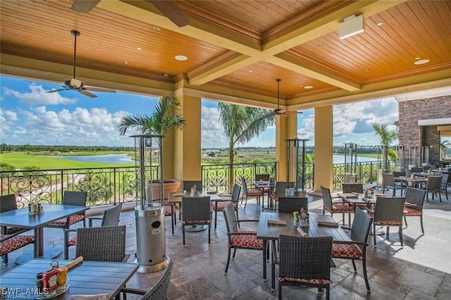 view of patio featuring a gazebo, a water view, ceiling fan, and an outdoor fireplace