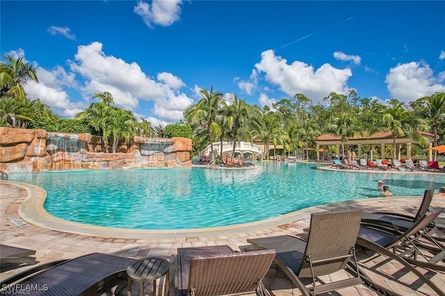 view of pool featuring pool water feature and a patio